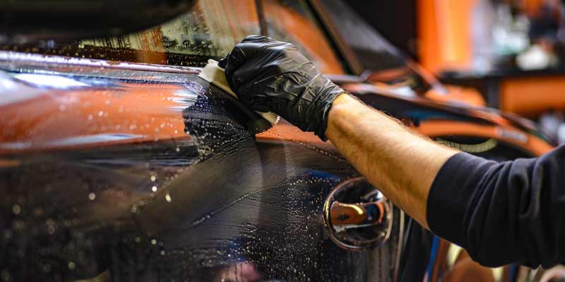 man applying car paint protection film